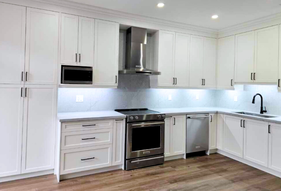 Modern kitchen renovation in Woodbridge with dark engineered wood flooring and white cabinetry