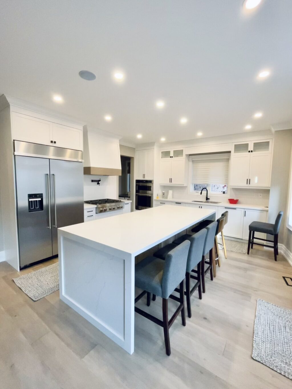 Woodbridge kitchen renovation with white cabinets, quartz countertop, and light wood flooring