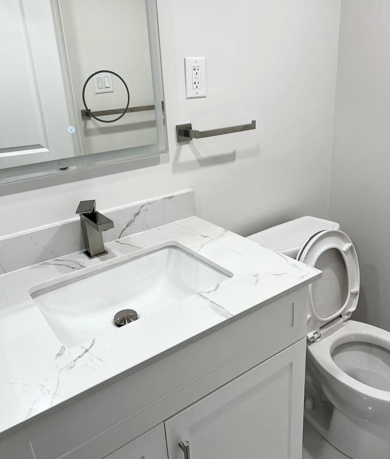 Oshawa bathroom renovation featuring LED mirror and bright white tiles